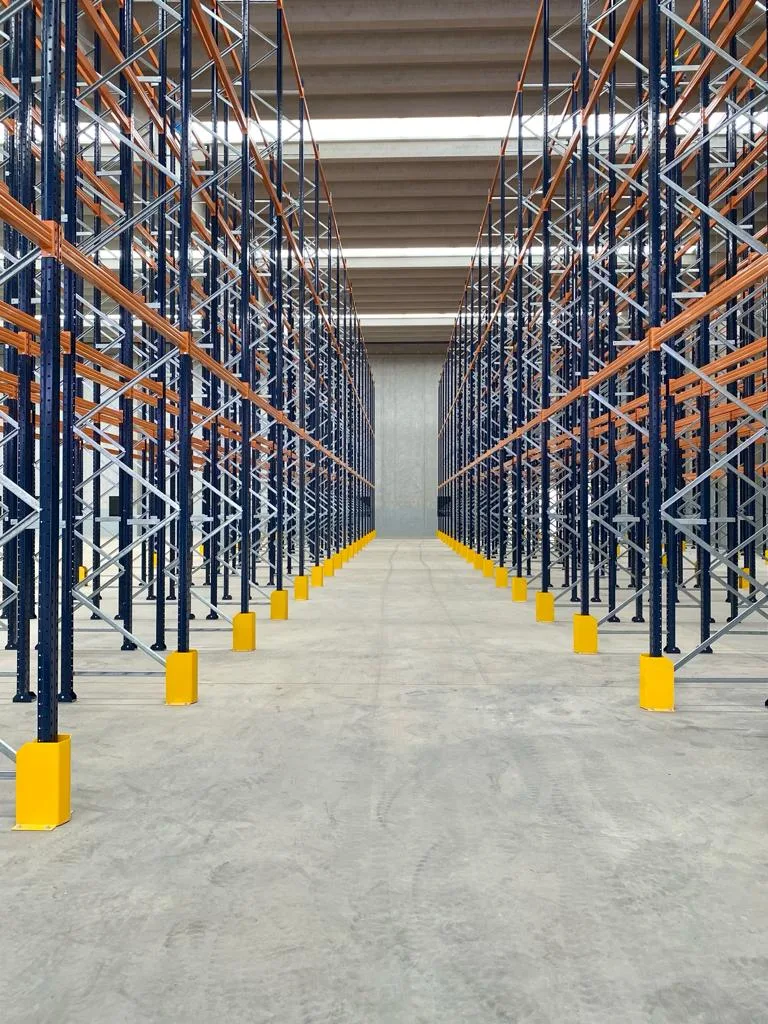 Corredor de porta-pallets com bases amarelas em galpão de armazenagem
